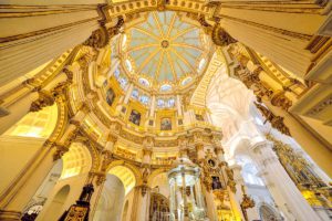 Wide perspective over a cathedral ceiling architecture decorated with marble and glass, in Malaga